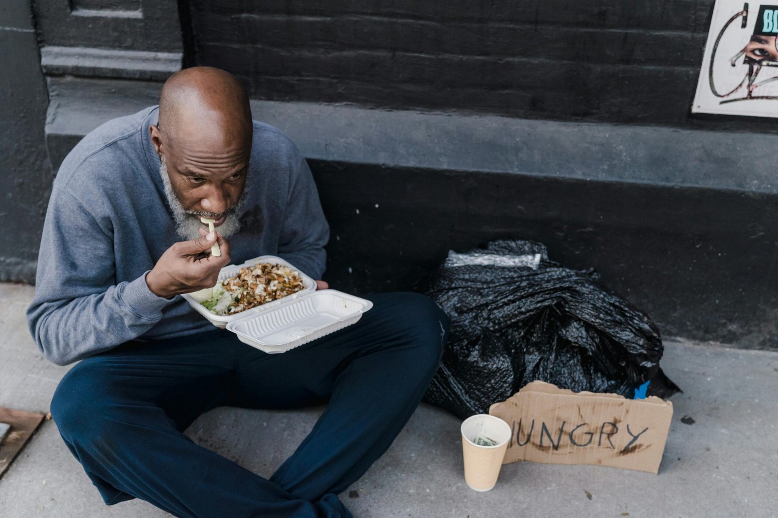 Homeless man with food container and 